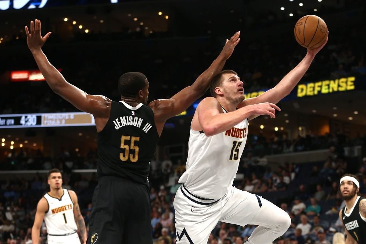 Apr 14, 2024; Memphis, Tennessee, USA; Denver Nuggets center Nikola Jokic (15) drives to the basket as Memphis Grizzlies center Trey Jemison (55) defends during the first half at FedExForum.