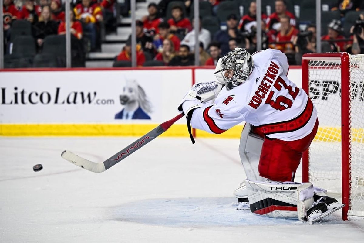 Dec 7, 2023; Calgary, Alberta, CAN; Carolina Hurricanes goaltender Pyotr Kochetkov (52) passes the puck during the third period of a game against the Calgary Flames at Scotiabank Saddledome.