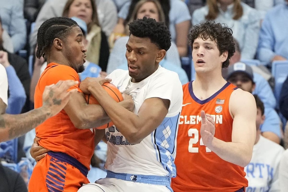Feb 6, 2024; Chapel Hill, North Carolina, USA; North Carolina Tar Heels forward Jalen Washington (13) and Clemson Tigers forward Chauncey Wiggins (21) and Clemson Tigers center PJ Hall (24) fight for the ball in the first half at Dean E. Smith Center.