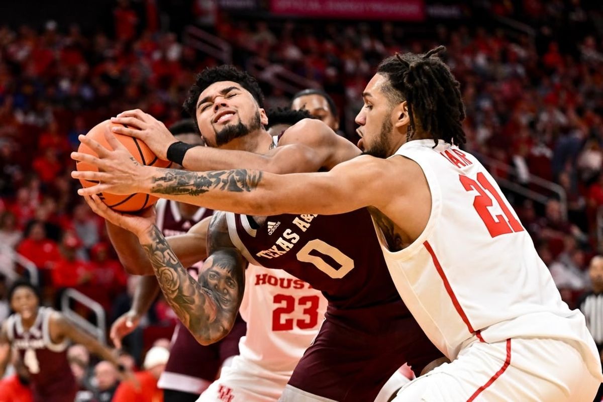 Dec 16, 2023; Houston, Texas, USA; Texas A&M Aggies guard Jace Carter (0) is blocked by Houston Cougars guard Emanuel Sharp (21) during the first half at Toyota Center.
