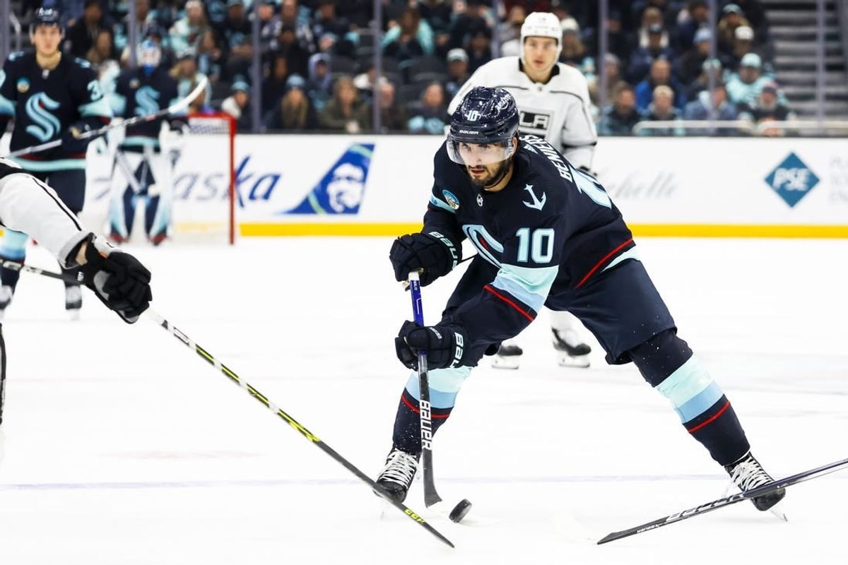 Dec 16, 2023; Seattle, Washington, USA; Seattle Kraken center Matty Beniers (10) flips the puck forward against the Los Angeles Kings during the second period at Climate Pledge Arena.
