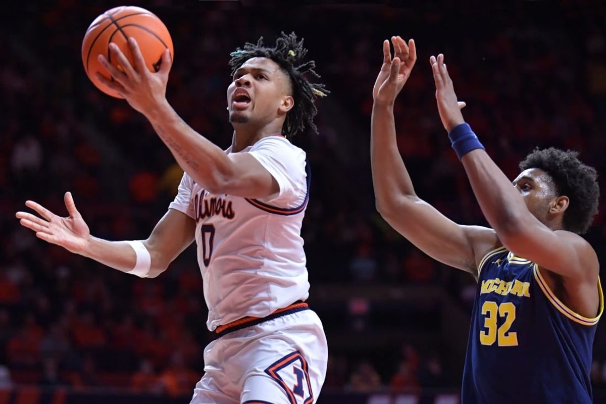 Feb 13, 2024; Champaign, Illinois, USA; Illinois Fighting Illini guard Terrence Shannon Jr. (0) drives past Michigan Wolverines forward Tarris Reed Jr. (32) on his way to the basket during the first half at State Farm Center.