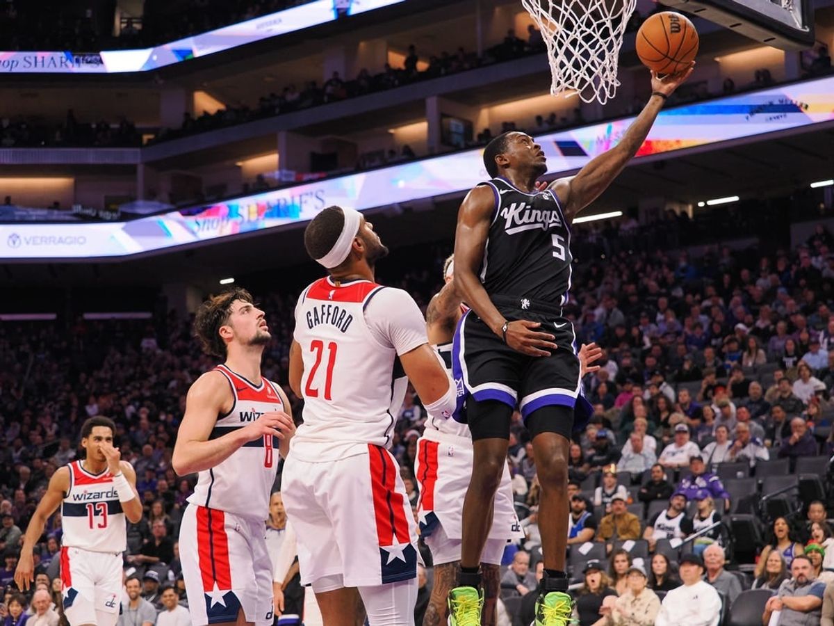 Dec 18, 2023; Sacramento, California, USA; Sacramento Kings guard De'Aaron Fox (5) scores a layup against Washington Wizards center Daniel Gafford (21) during the second quarter at Golden 1 Center.