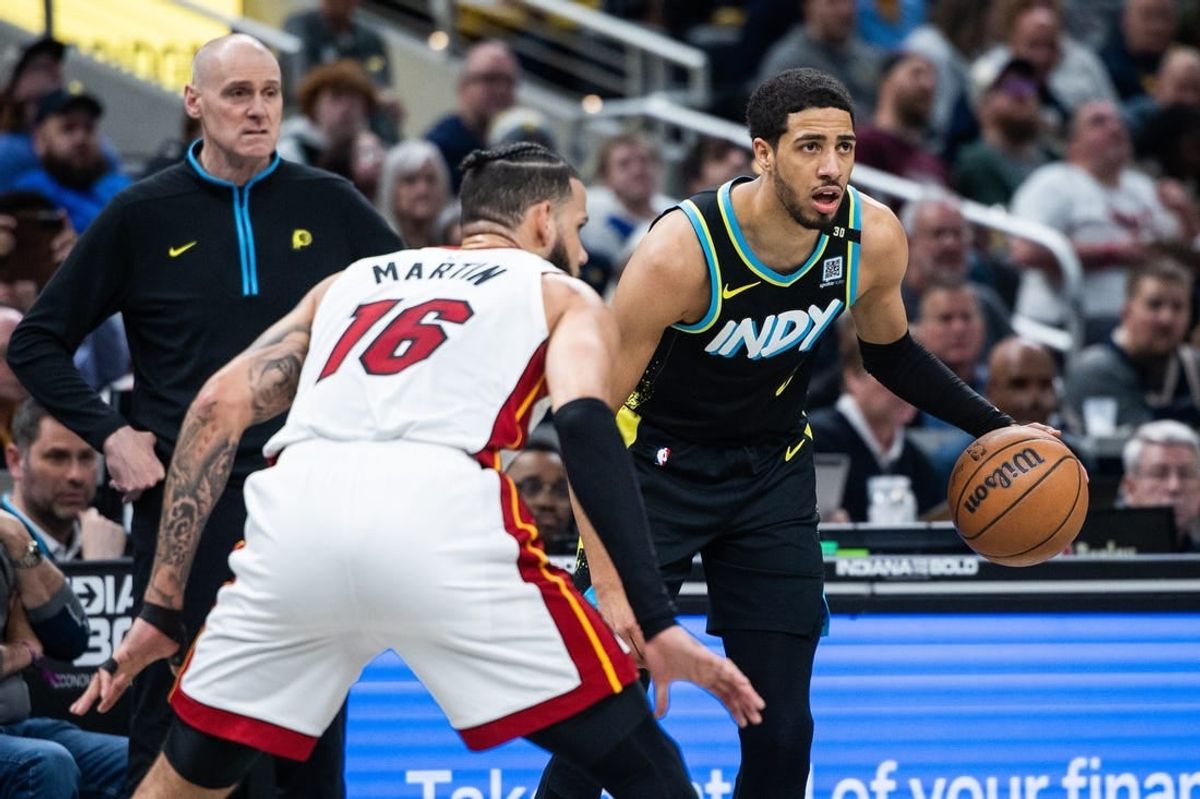 Apr 7, 2024; Indianapolis, Indiana, USA;  Indiana Pacers guard Tyrese Haliburton (0) dribbles the ball while  Miami Heat forward Caleb Martin (16) defends in the first half at Gainbridge Fieldhouse.