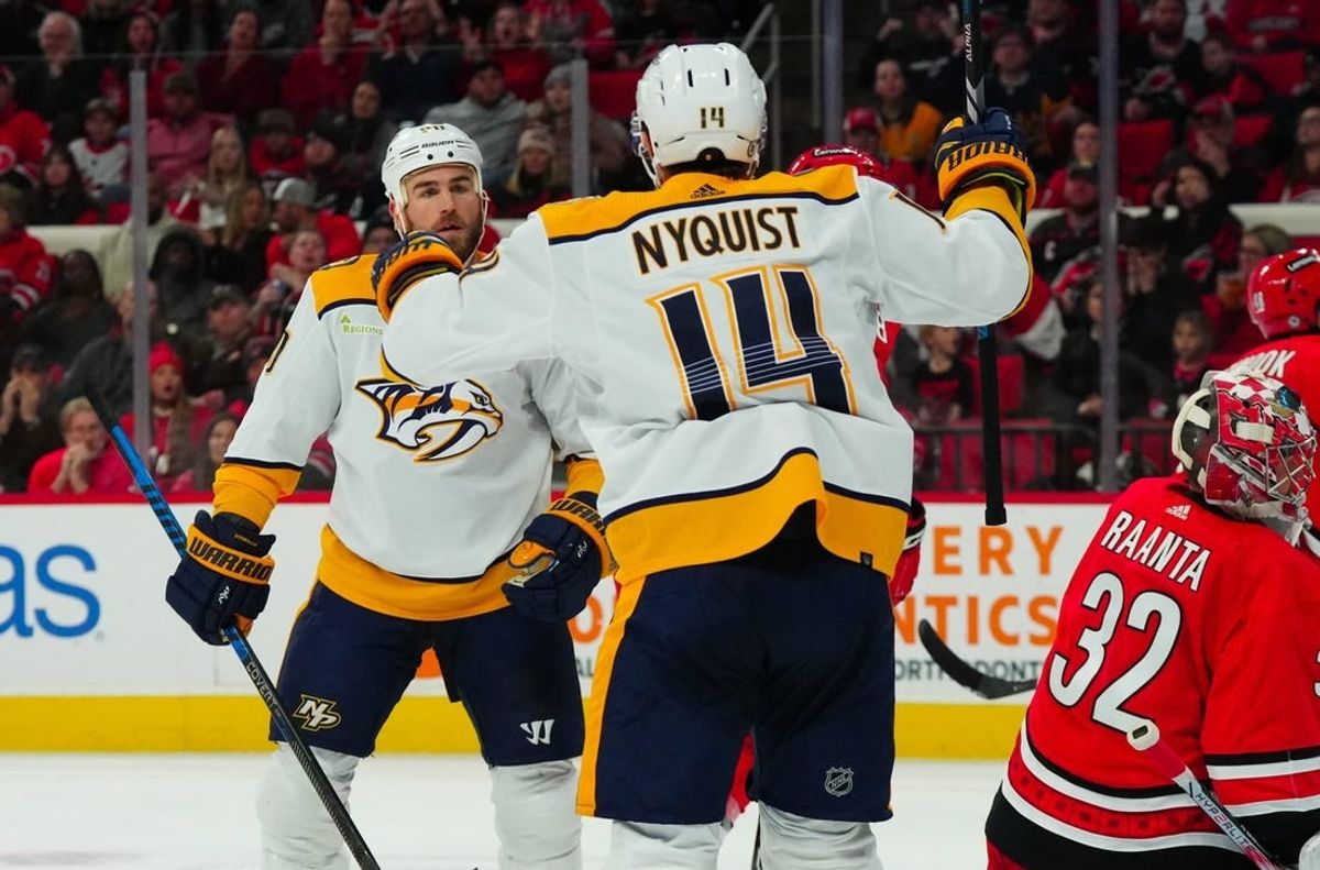 Dec 15, 2023; Raleigh, North Carolina, USA; Nashville Predators center Ryan O'Reilly (90) celebrates his gaol with center Gustav Nyquist (14) past Carolina Hurricanes goaltender Antti Raanta (32)  during the second period at PNC Arena.
