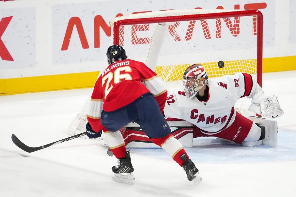 Nov 10, 2023; Sunrise, Florida, USA; Florida Panthers defenseman Uvis Balinskis (26) scores a goal past Carolina Hurricanes goaltender Antti Raanta (32) during the first period at Amerant Bank Arena.