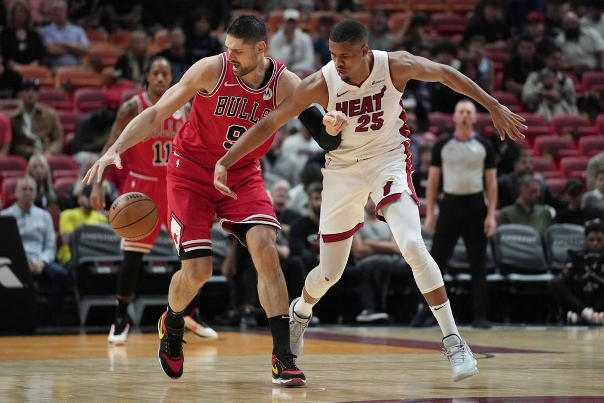 Dec 14, 2023; Miami, Florida, USA; Chicago Bulls center Nikola Vucevic (9) intercepts a pass intended for Miami Heat center Orlando Robinson (25) during the first half at Kaseya Center.
