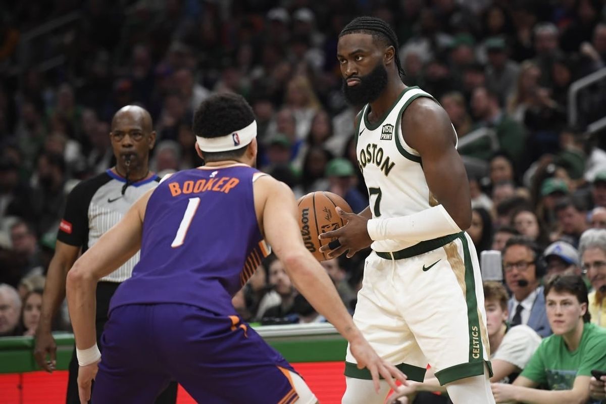 Mar 14, 2024; Boston, Massachusetts, USA;  Boston Celtics guard Jaylen Brown (7) controls the ball while Phoenix Suns guard Devin Booker (1) defends during the second half at TD Garden.