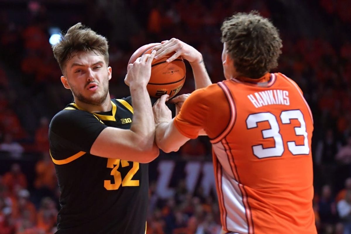Illinois Fighting Illini forward Coleman Hawkins (33) and Iowa Hawkeyes forward Owen Freeman (32) wrestle for a rebound during the second half at State Farm Center.