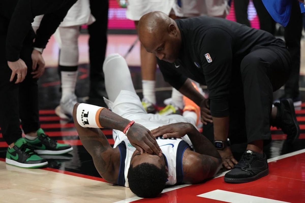 Dec 8, 2023; Portland, Oregon, USA; Dallas Mavericks point guard Kyrie Irving (11) is checked by a staff member during the first half against the Portland Trail Blazers at Moda Center.