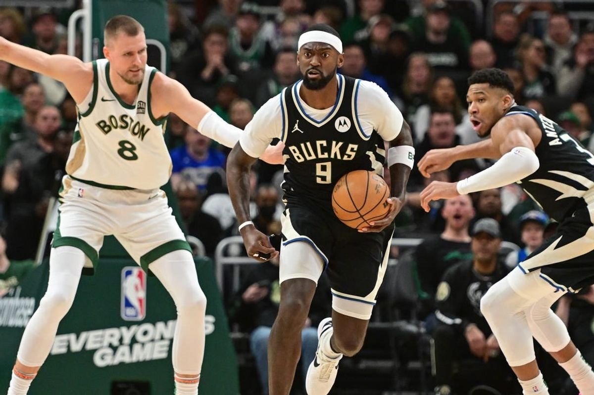 Jan 11, 2024; Milwaukee, Wisconsin, USA;  Milwaukee Bucks forward Bobby Portis (9) brings the ball down court against Boston Celtics center Kristaps Porzingis (8) in the second quarterat Fiserv Forum.