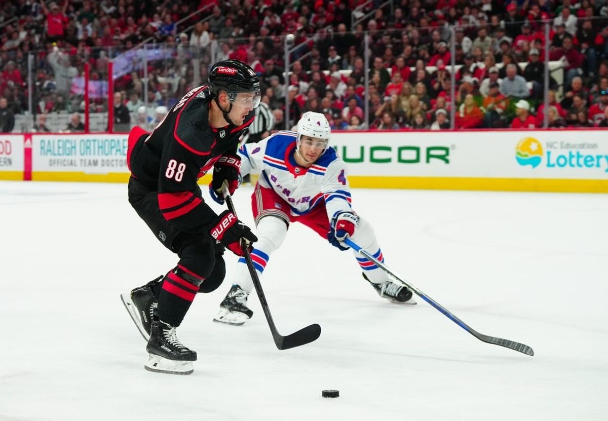 May 9, 2024; Raleigh, North Carolina, USA; Carolina Hurricanes center Martin Necas (88) skates with the puck past New York Rangers defenseman Braden Schneider (4) during the first period in game three of the second round of the 2024 Stanley Cup Playoffs at PNC Arena.