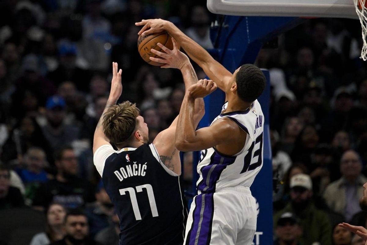 Jan 27, 2024; Dallas, Texas, USA; Sacramento Kings forward Keegan Murray (13) blocks a shot by Dallas Mavericks guard Luka Doncic (77) during the second quarter at the American Airlines Center.