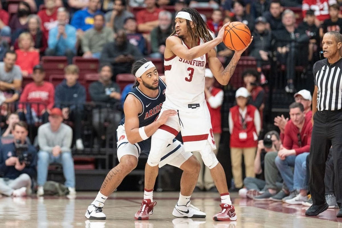 Dec 31, 2023; Stanford, California, USA; Stanford Cardinal guard Kanaan Carlyle (3) keeps the ball away from Arizona Wildcats guard Kylan Boswell (4) during the second half at Maples Pavilion.