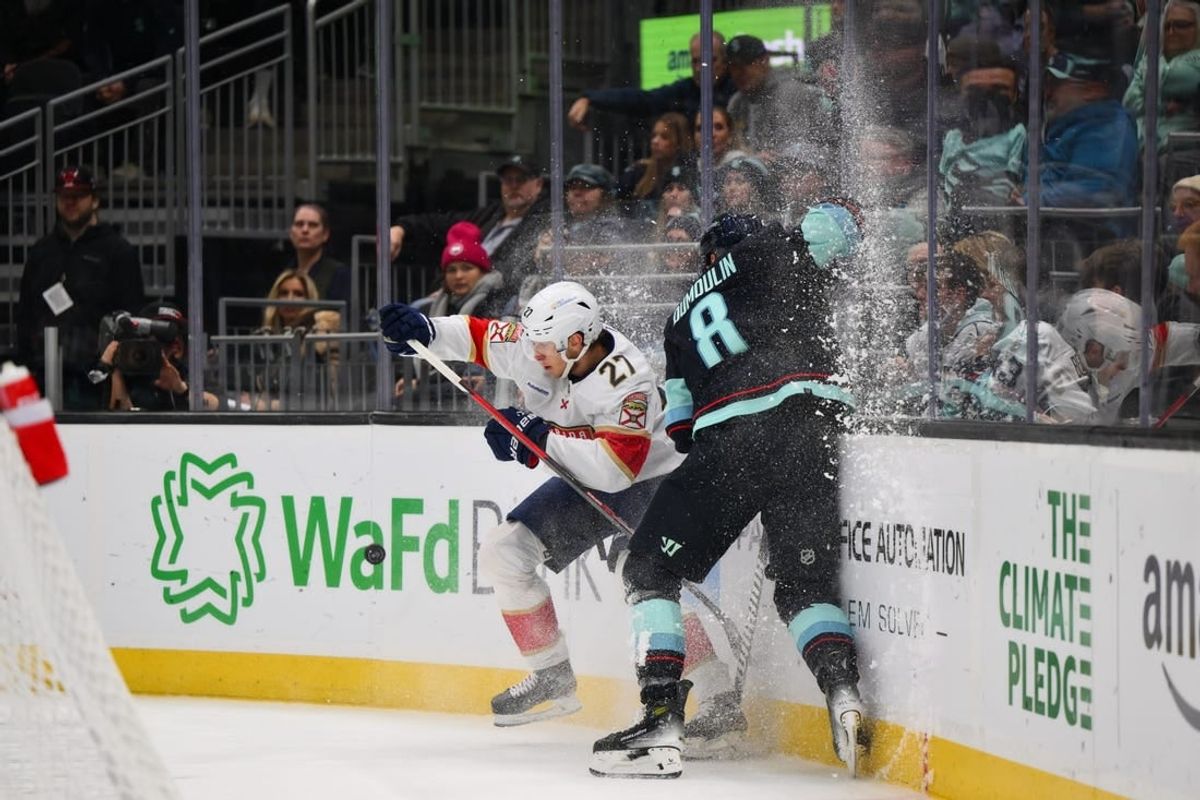 Dec 12, 2023; Seattle, Washington, USA; Florida Panthers center Eetu Luostarinen (27) checks Seattle Kraken defenseman Brian Dumoulin (8) into the wall during the first period at Climate Pledge Arena.