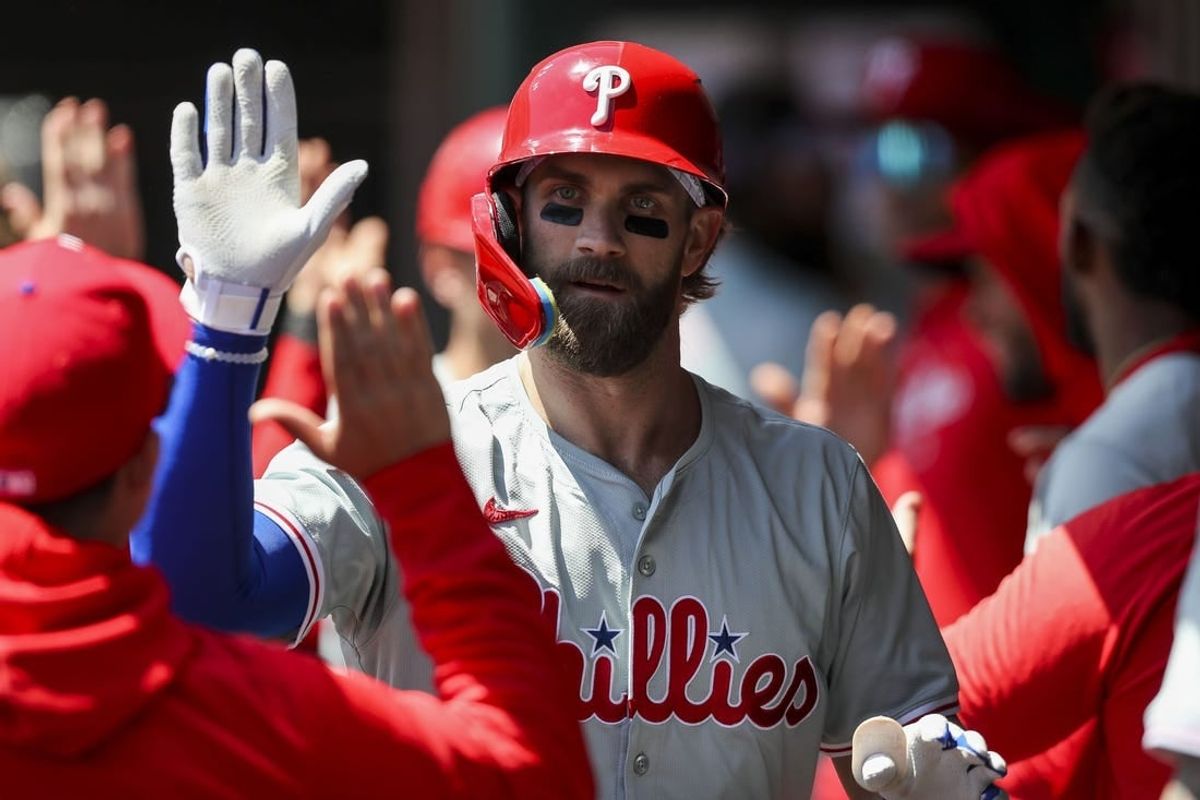 Apr 25, 2024; Cincinnati, Ohio, USA; Philadelphia Phillies first baseman Bryce Harper (3) high fives teammates after hitting a two-run home run in the third inning against the Cincinnati Reds at Great American Ball Park.