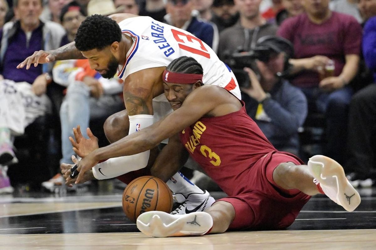 Apr 7, 2024; Los Angeles, California, USA; Los Angeles Clippers forward Paul George (13) and Cleveland Cavaliers guard Caris LeVert (3) scramble for a loose ball in the first half at Crypto.com Arena.