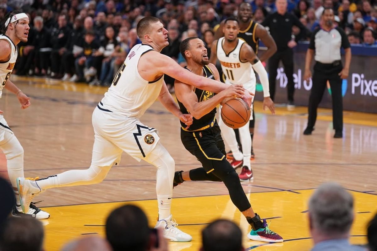 Apr 27, 2022; San Francisco, California, USA; Golden State Warriors guard Stephen Curry (30) has the ball knocked out of his hands by Denver Nuggets center Nikola Jokic (15) in the third quarter during game five of the first round for the 2022 NBA playoffs at Chase Center.