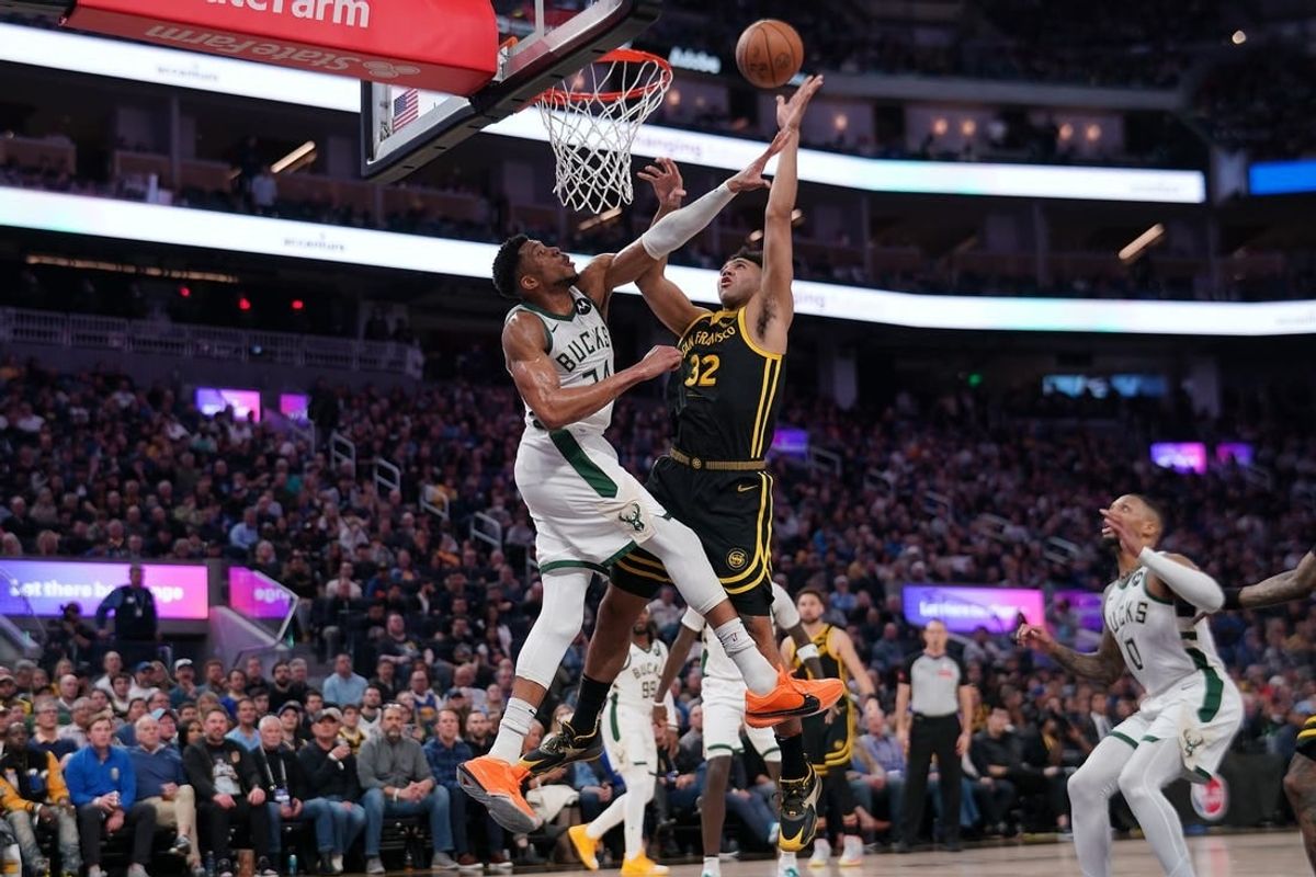 Mar 6, 2024; San Francisco, California, USA; Golden State Warriors forward Trayce Jackson-Davis (32) makes a shot over Milwaukee Bucks forward Giannis Antetokounmpo (34) in the third quarter at the Chase Center.
