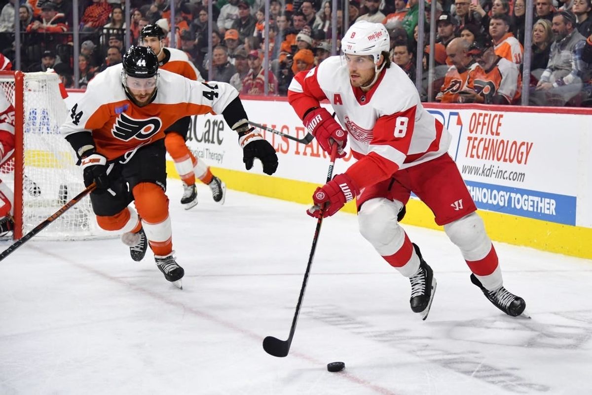 Dec 16, 2023; Philadelphia, Pennsylvania, USA; Detroit Red Wings defenseman Ben Chiarot (8) skates with the puck against Philadelphia Flyers left wing Nicolas Deslauriers (44) during the third period at Wells Fargo Center.