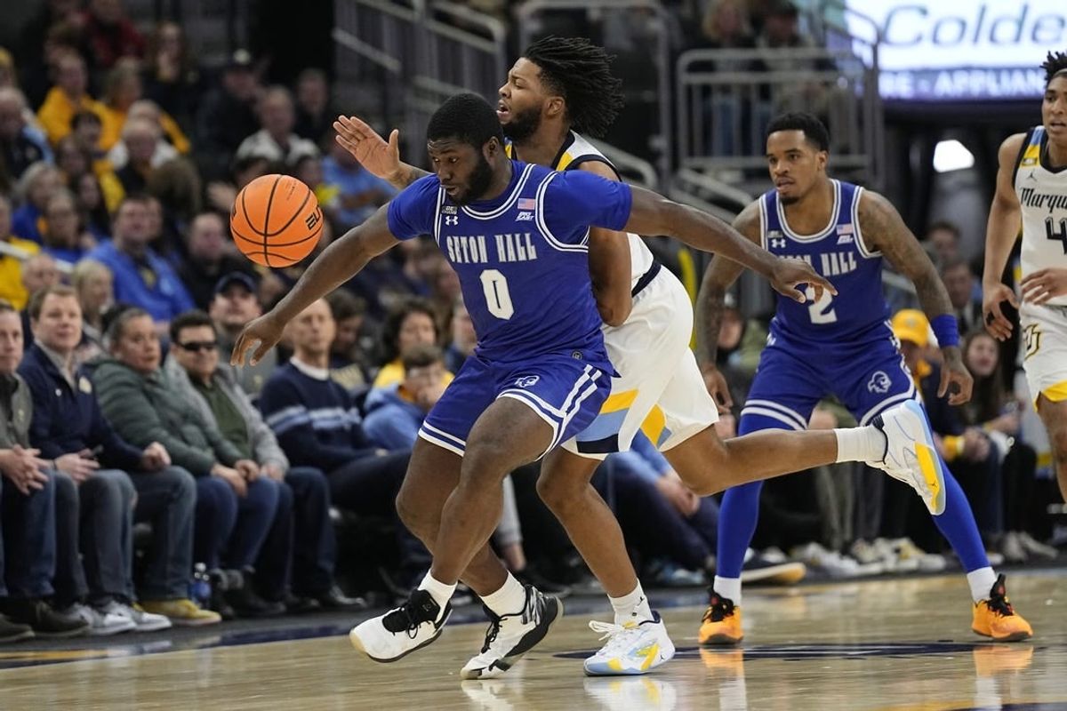 Jan 27, 2024; Milwaukee, Wisconsin, USA;  Seton Hall Pirates guard Dylan Addae-Wusu (0) and Marquette Golden Eagles forward David Joplin (23) chase the loose ball during the second half at Fiserv Forum.