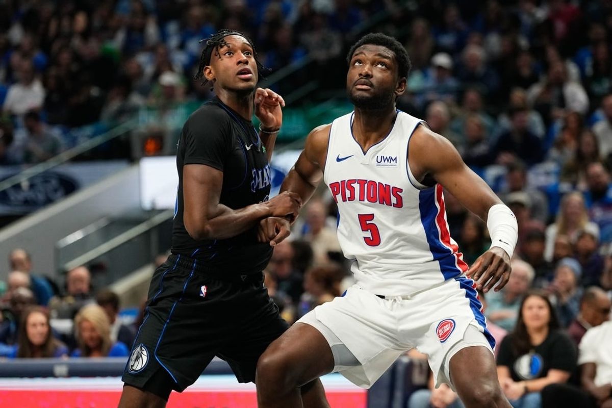 Apr 12, 2024; Dallas, Texas, USA; Dallas Mavericks forward Olivier-Maxence Prosper (18) and Detroit Pistons forward Chimezie Metu (5) battle for position during the first half at American Airlines Center.
