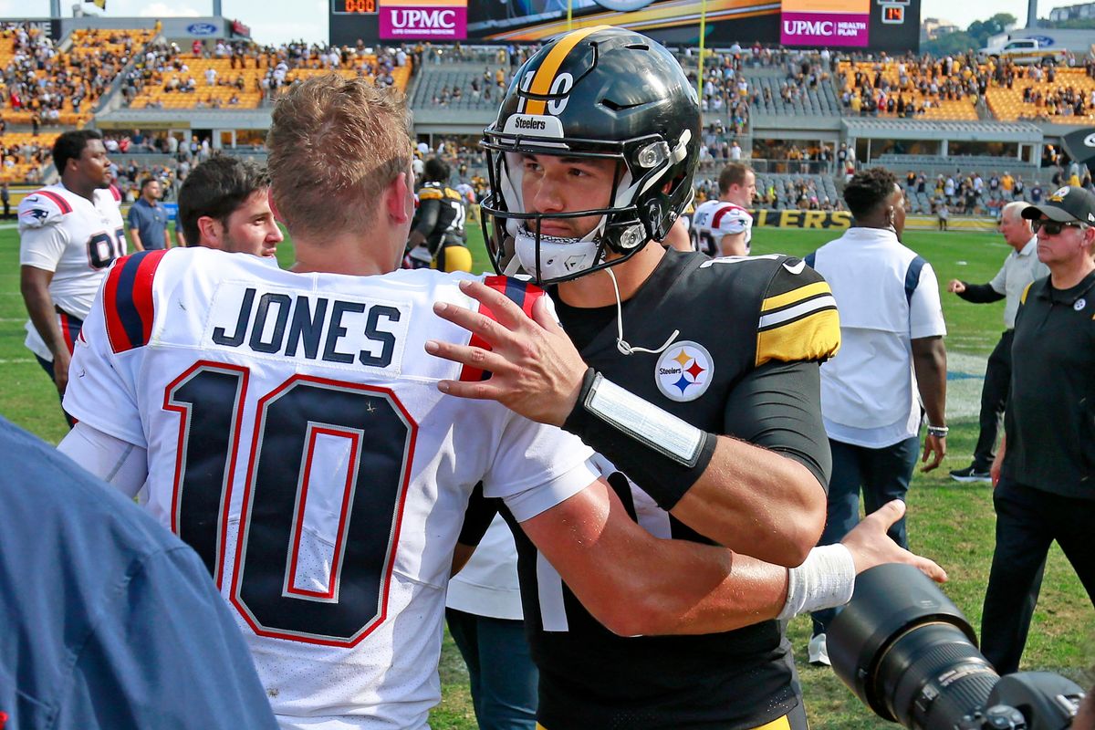 QBs Mac Jones and Mitch Trubisky share a moment after Pats’ win.