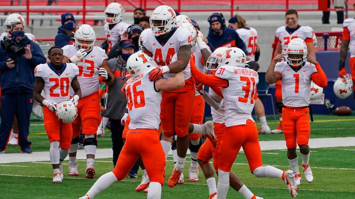 Illinois linebacker Tarique Barnes (44) celebrates with teammates after he intercepted a pass.