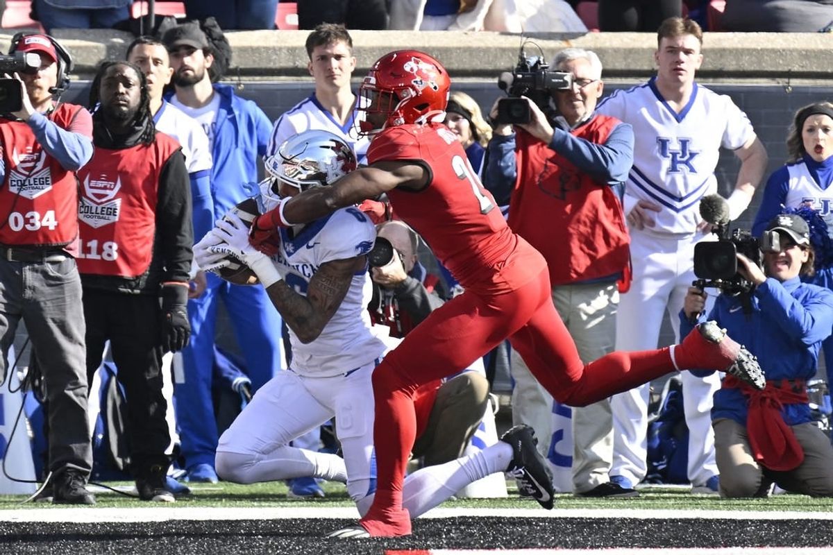 Nov 25, 2023; Louisville, Kentucky, USA;  Kentucky Wildcats wide receiver Dane Key (6) catches a touchdown pass under the pressure of Louisville Cardinals defensive back Storm Duck (29) during the first half at L&N Federal Credit Union Stadium.
