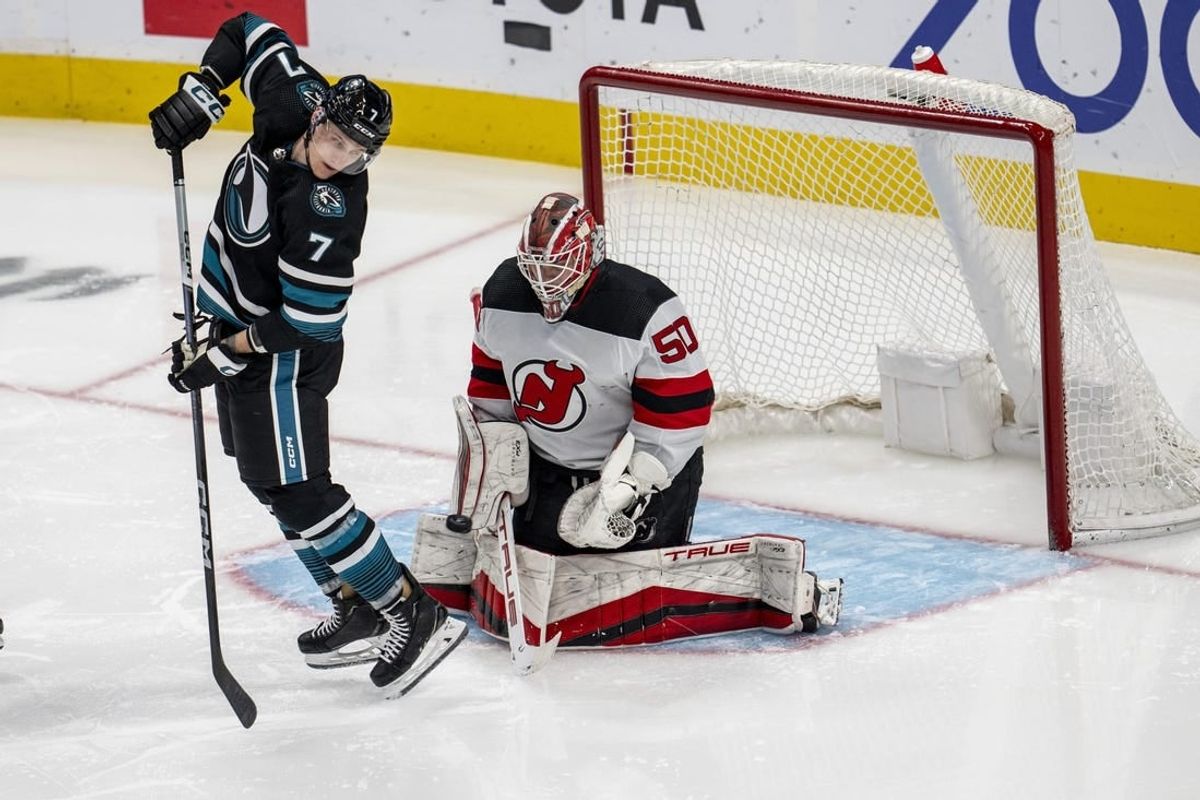 Feb 27, 2024; San Jose, California, USA;  New Jersey Devils goaltender Nico Daws (50) makes a save as San Jose Sharks center Nico Sturm (7) tries to deflect the puck into the net during the third period at SAP Center at San Jose.