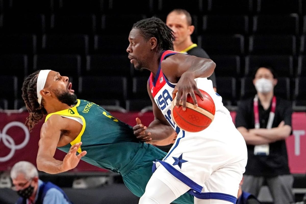 Aug 5, 2021; Saitama, Japan; United States guard Jrue Holiday (12) drives to the basket against Australia point guard Patty Mills (5) in the men's basketball semi final during the Tokyo 2020 Olympic Summer Games at Saitama Super Arena.
