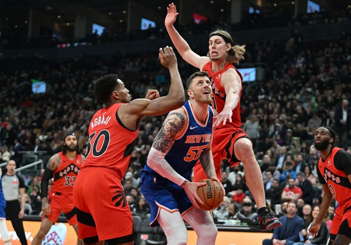Mar 27, 2024; Toronto, Ontario, CAN; New York Knicks center Isaiah Hartenstein (55) drives against Toronto Raptors forward Kelly Olynyk (41) and guard Ochai Agbaji (30) in the first half at Scotiabank Arena.