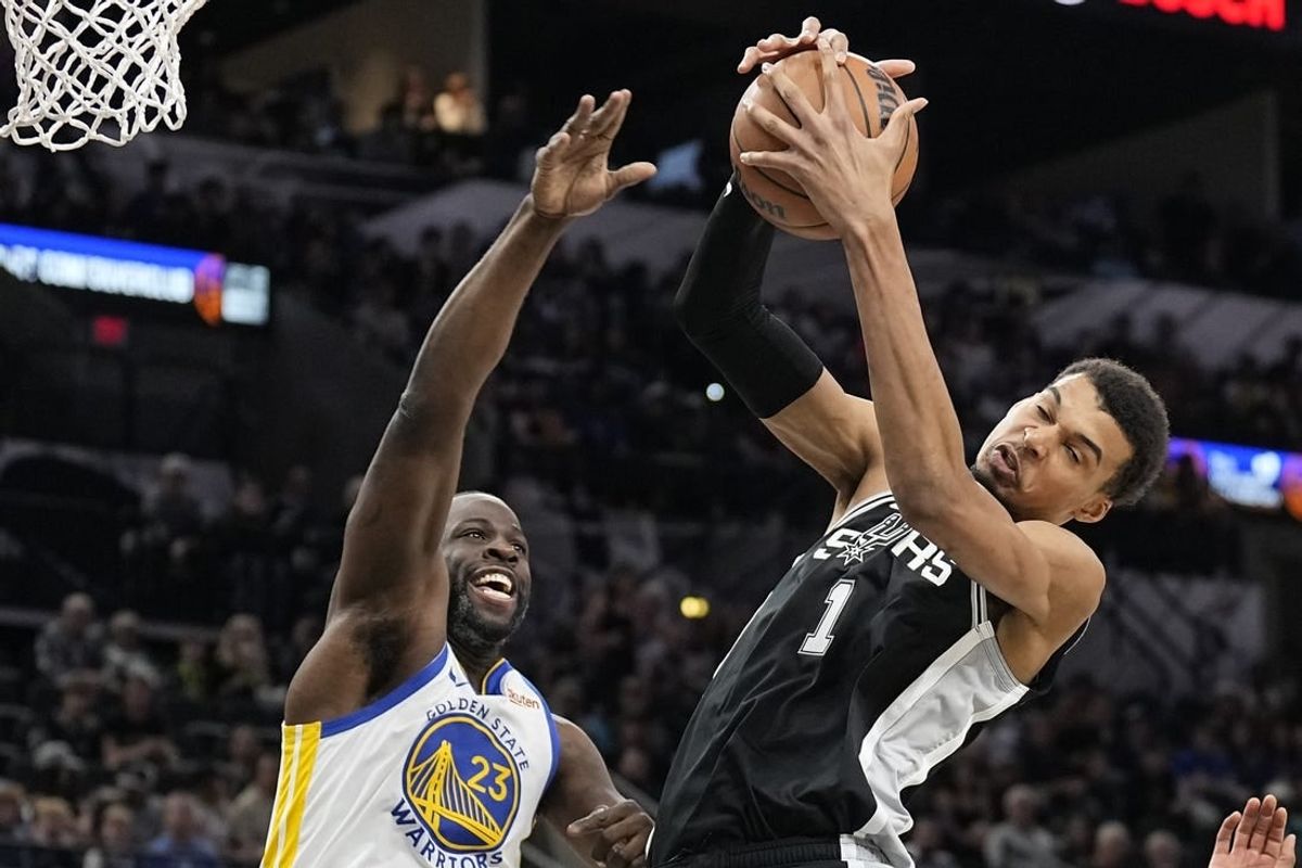 Mar 11, 2024; San Antonio, Texas, USA; San Antonio Spurs forward Victor Wembanyama (1) grabs a rebound away from Golden State Warriors forward Draymond Green (23) during the first half at Frost Bank Center.