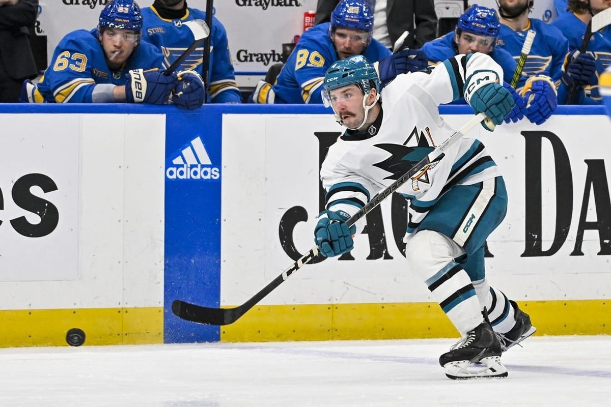 Mar 30, 2024; St. Louis, Missouri, USA;  San Jose Sharks defenseman Kyle Burroughs (4) shoots against the St. Louis Blues during the third period at Enterprise Center.