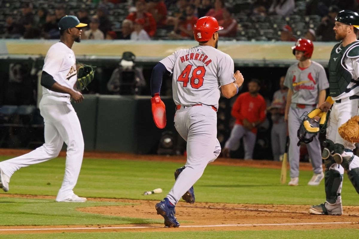 Apr 16, 2024; Oakland, California, USA; St. Louis Cardinals designated hitter Ivan Herrera (48) scores a run between  Oakland Athletics relief pitcher Dany Jimenez (56) and catcher Kyle McCann (52) during the sixth inning at Oakland-Alameda County Coliseum.