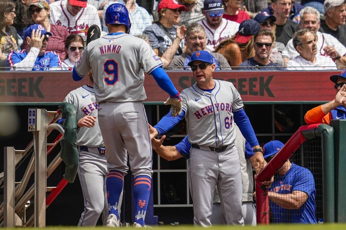 Apr 11, 2024; Cumberland, Georgia, USA; New York Mets left fielder Brandon Nimmo (9) reacts with manager Carlos Mendoza (64) after scoring a run against the Atlanta Braves during the second inning at Truist Park.