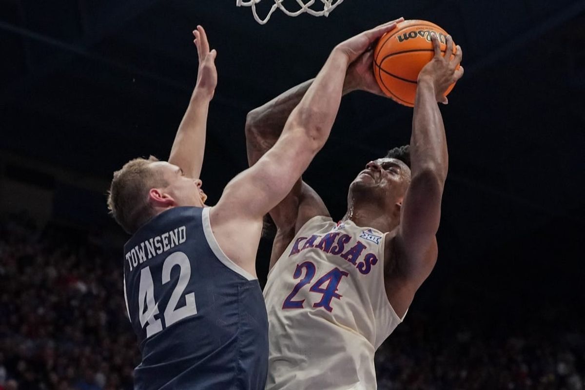 Dec 22, 2023; Lawrence, Kansas, USA; Kansas Jayhawks forward K.J. Adams Jr. (24) shoots and is fouled by Yale Bulldogs forward Nick Townsend (42) during the second half at Allen Fieldhouse.