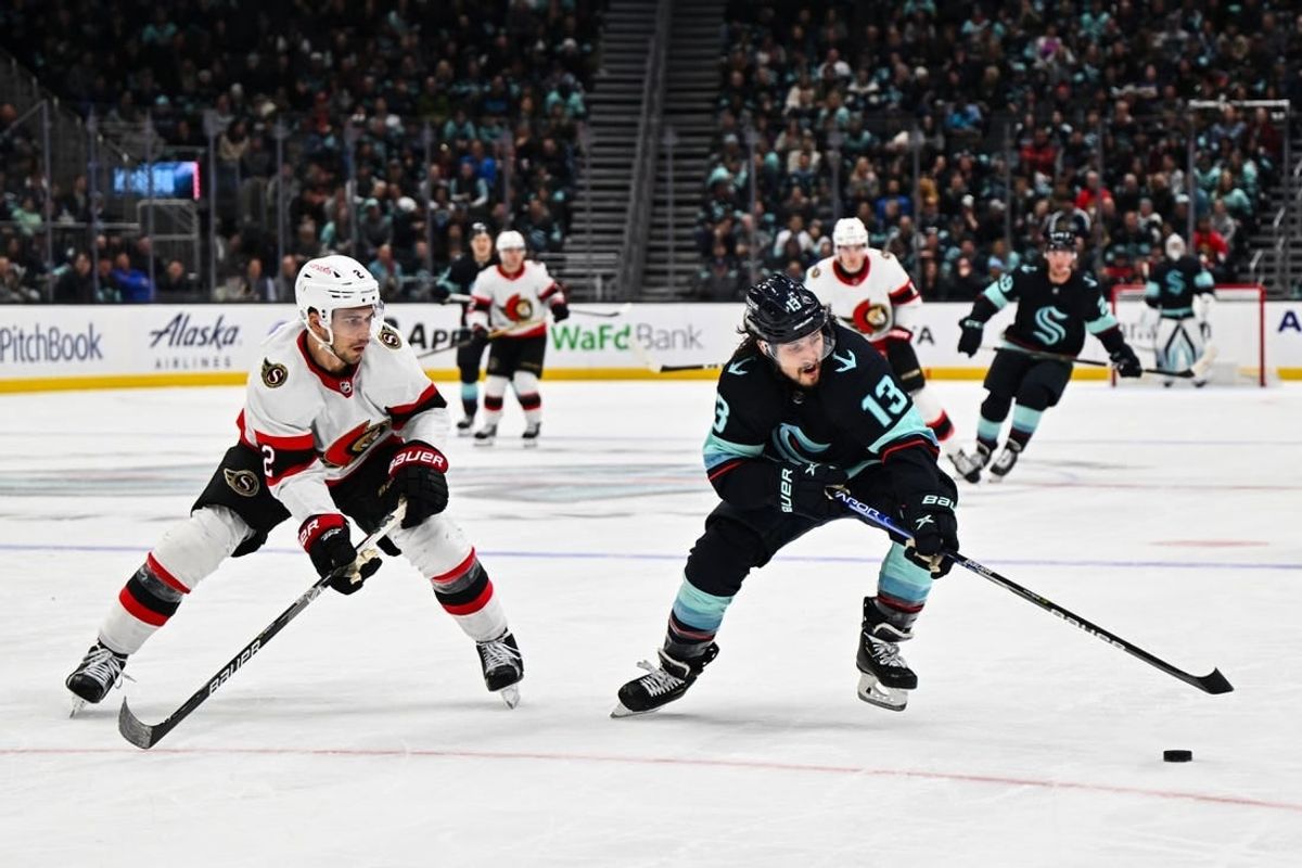 Mar 9, 2023; Seattle, Washington, USA; Seattle Kraken left wing Brandon Tanev (13) plays the puck while being defended by Ottawa Senators defenseman Artem Zub (2) during the third period at Climate Pledge Arena. Ottawa defeated Seattle 5-4.
