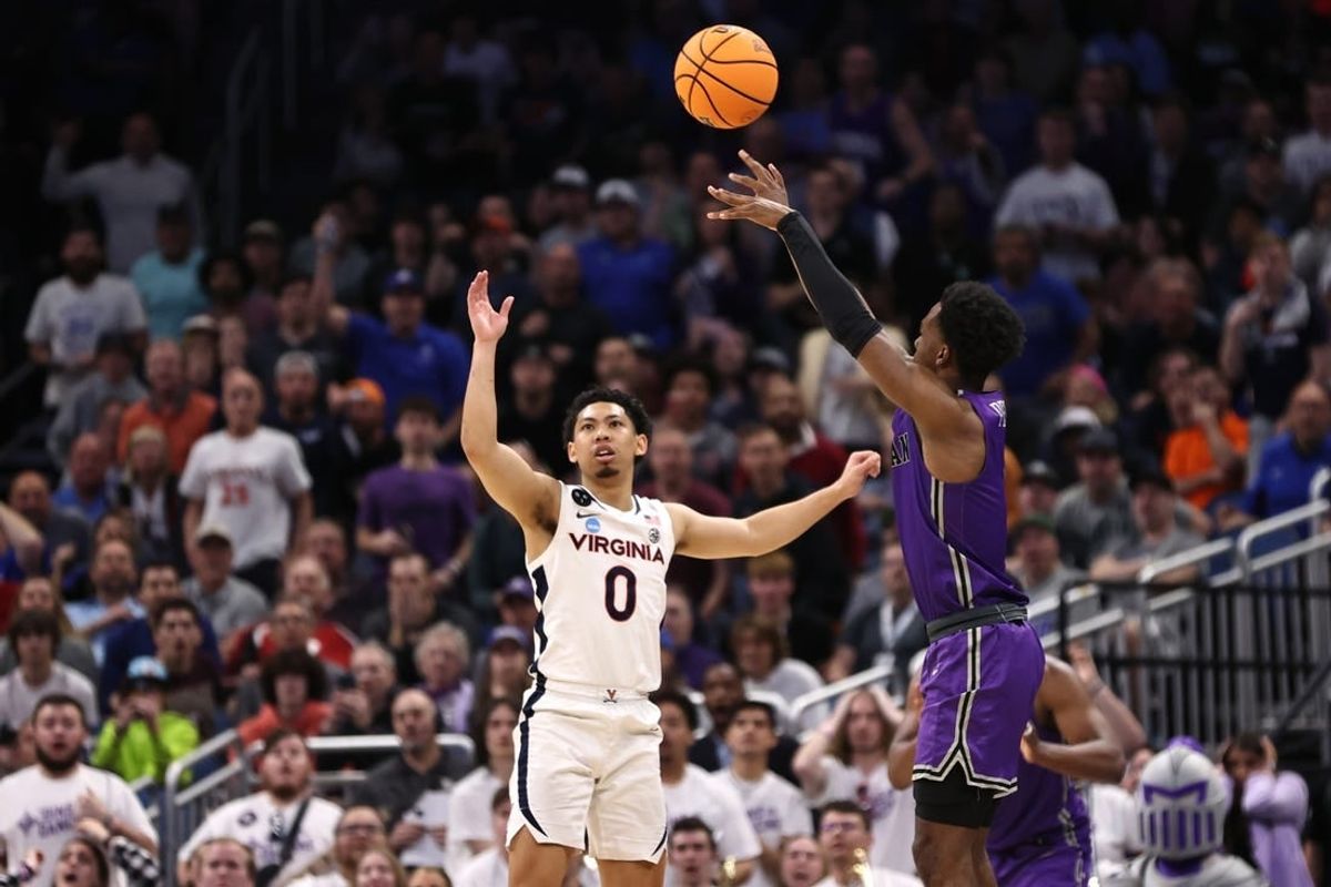 Mar 16, 2023; Orlando, FL, USA; Furman Paladins guard JP Pegues (1) shoots a three-point basket during the second half as Virginia Cavaliers guard Kihei Clark (0) looks on at Amway Center.