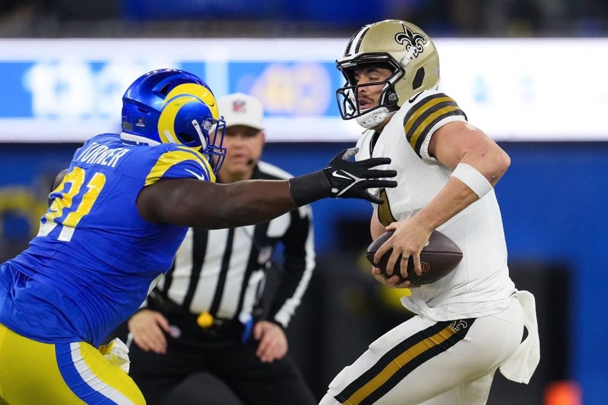 Dec 21, 2023; Inglewood, California, USA; New Orleans Saints quarterback Derek Carr (4) is sacked by Los Angeles Rams defensive tackle Kobie Turner (91) in the first half at SoFi Stadium.