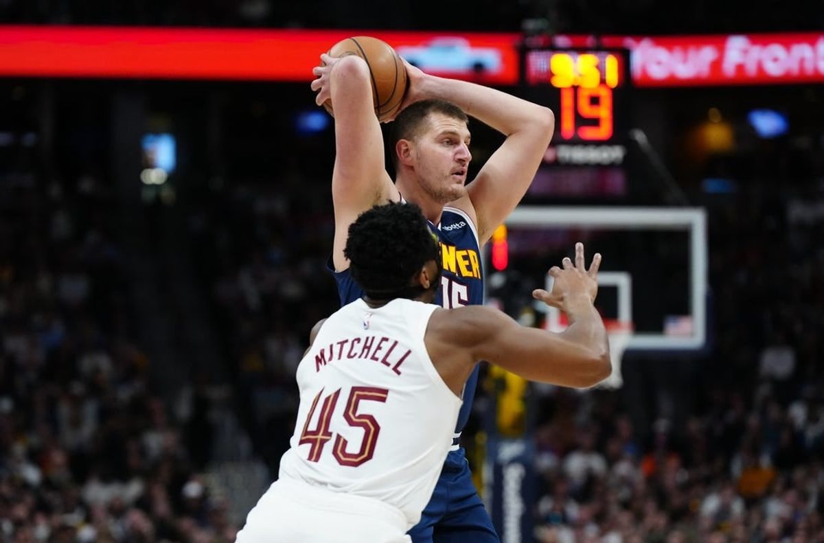 Mar 31, 2024; Denver, Colorado, USA; Denver Nuggets center Nikola Jokic (15) prepares to pass the ball over Cleveland Cavaliers guard Donovan Mitchell (45) in the first quarter at Ball Arena.