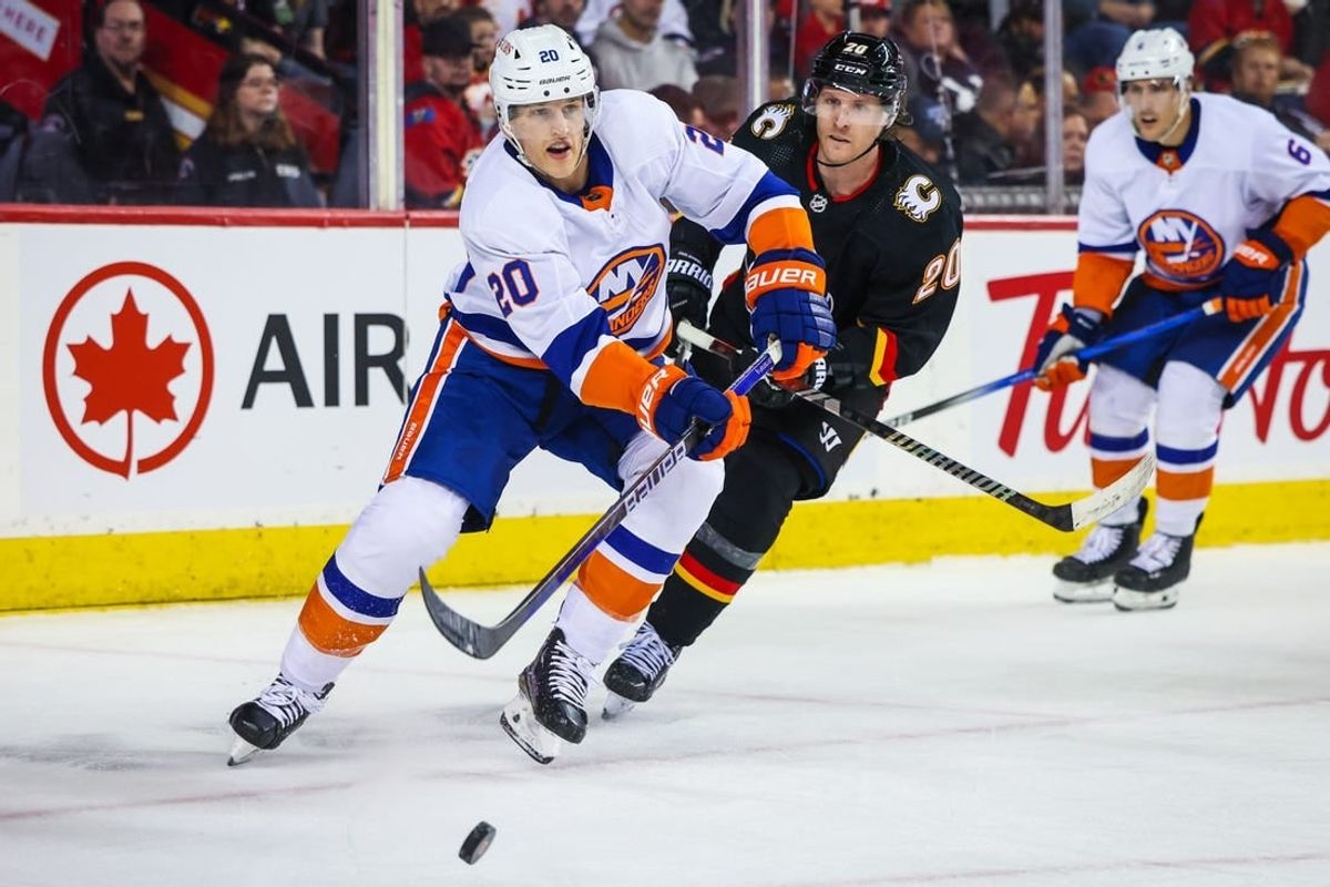 Nov 18, 2023; Calgary, Alberta, CAN; New York Islanders right wing Hudson Fasching (20) passes the puck against the Calgary Flames during the second period at Scotiabank Saddledome.