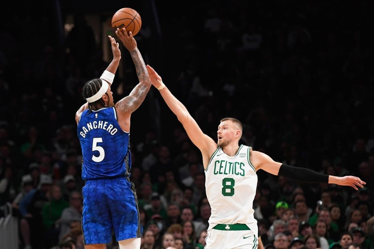 Dec 17, 2023; Boston, Massachusetts, USA;  Orlando Magic forward Paolo Banchero (5) shoots the ball over Boston Celtics center Kristaps Porzingis (8) during the second half at TD Garden.
