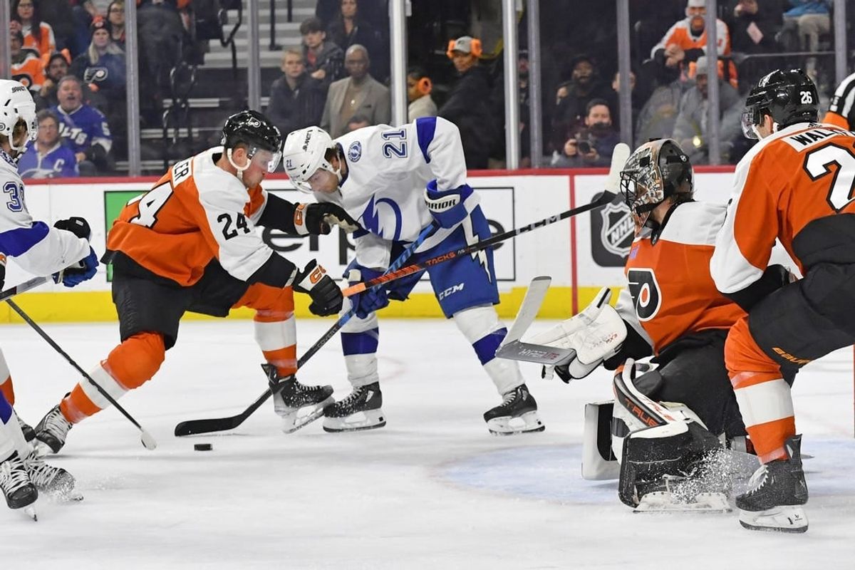 Feb 27, 2024; Philadelphia, Pennsylvania, USA; Tampa Bay Lightning center Brayden Point (21) and Philadelphia Flyers defenseman Nick Seeler (24) battle for the puck in front of goaltender Samuel Ersson (33) during the second period at Wells Fargo Center.
