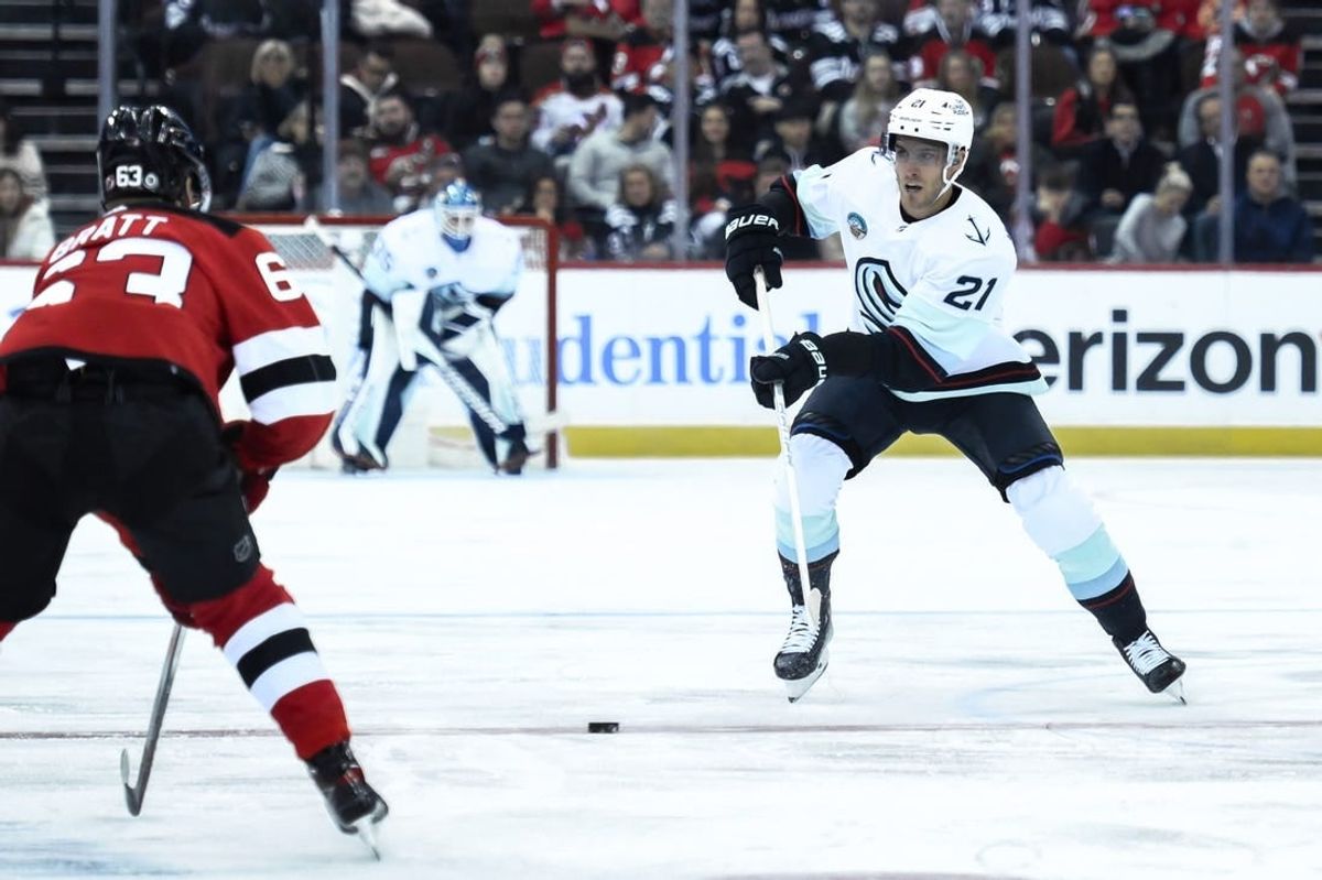 Feb 12, 2024; Newark, New Jersey, USA; Seattle Kraken center Alex Wennberg (21) skates with the puck against as New Jersey Devils left wing Jesper Bratt (63) defends during the first period at Prudential Center.
