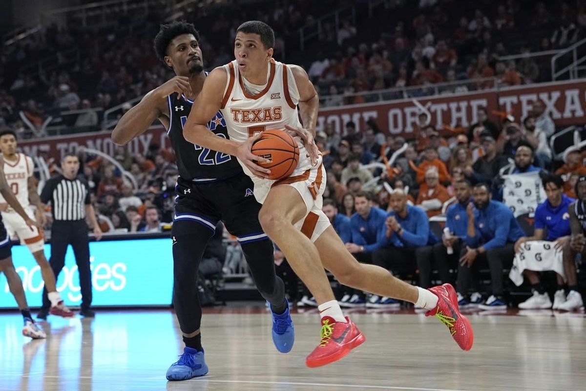 Jan 1, 2024; Austin, Texas, USA; Texas Longhorns forward Kadin Shedrick (5) drives to the basket while defended by Texas-Arlington Mavericks forward Shemar Wilson (22) during the first half at Moody Center.