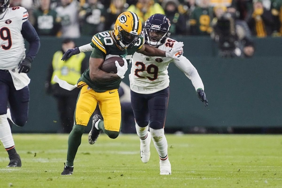 Jan 7, 2024; Green Bay, Wisconsin, USA;  Green Bay Packers wide receiver Bo Melton (80) rushes with the football in front of Chicago Bears cornerback Tyrique Stevenson (29) after catching a pass during the second quarter at Lambeau Field.