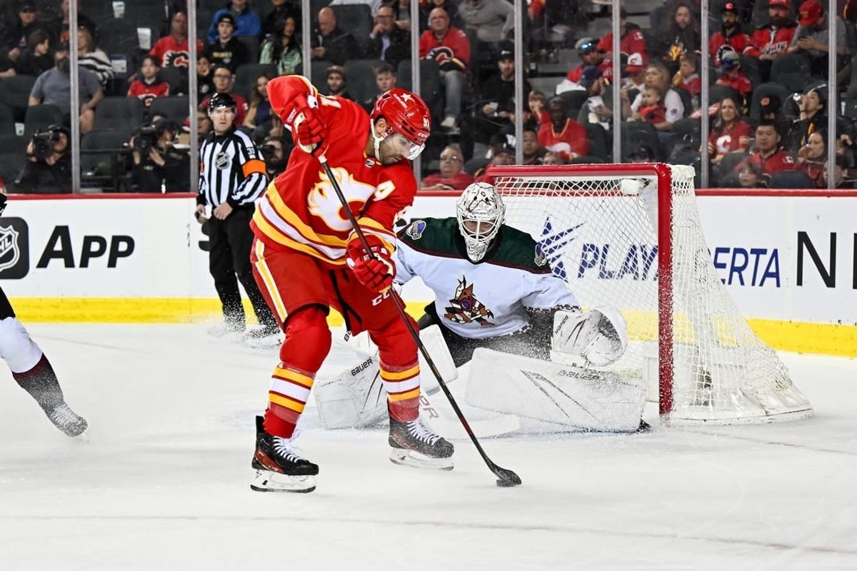 Apr 14, 2024; Calgary, Alberta, CAN; Calgary Flames center Nazem Kadri (91) makes a pass between his legs in front of Arizona Coyotes goaltender Connor Ingram (39) during the first period at Scotiabank Saddledome.