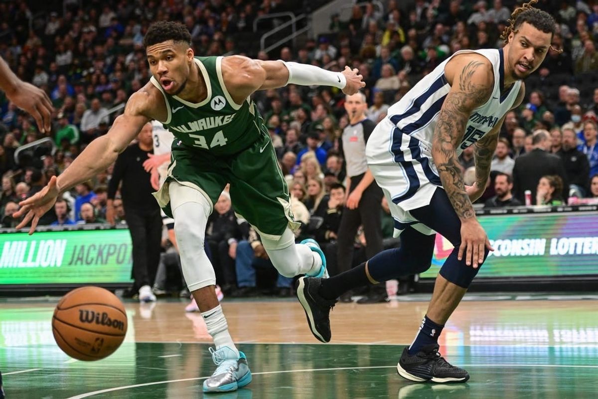 Apr 3, 2024; Milwaukee, Wisconsin, USA; Milwaukee Bucks forward Giannis Antetokounmpo (34) and Memphis Grizzlies center Brandon Clarke (15) reach for the ball in the in the fourth quarter at Fiserv Forum.