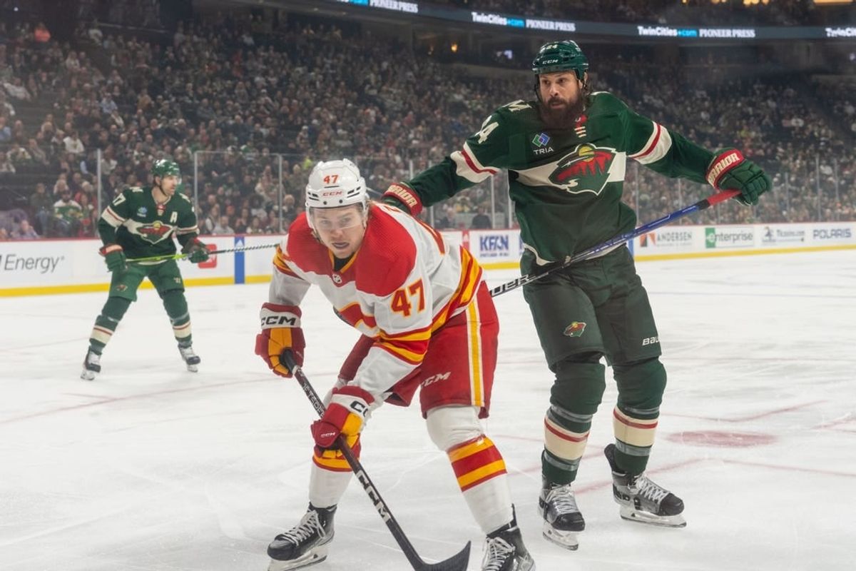 Dec 14, 2023; Saint Paul, Minnesota, USA; Calgary Flames center Connor Zary (47) is challenged by Minnesota Wild defenseman Zach Bogosian (24) in the first period at Xcel Energy Center.